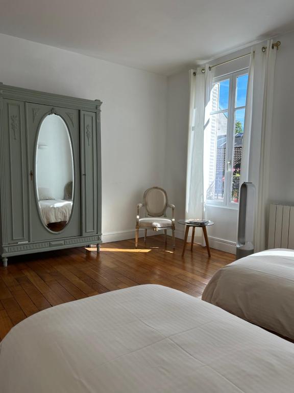 - une chambre avec une commode avec un miroir et une chaise dans l'établissement Le Lys, à Épernay