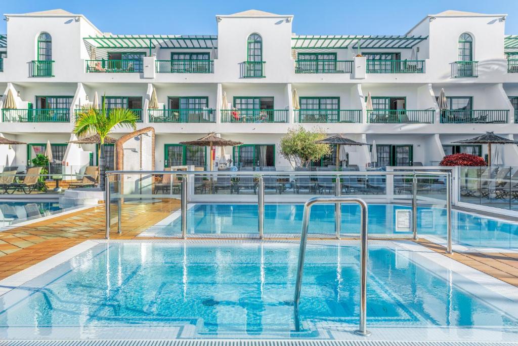 a swimming pool in front of a building at Club del Carmen in Puerto del Carmen