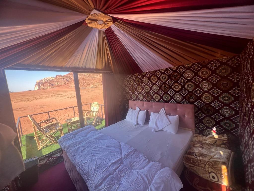 a bedroom with a bed with a view of the desert at Wadi Rum Desert Goals camp in Wadi Rum