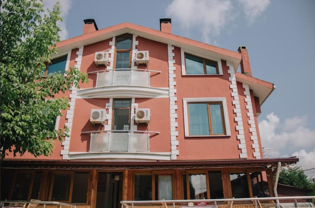 a pink building with a balcony on top of it at Ayisigi Hotel in Ağva