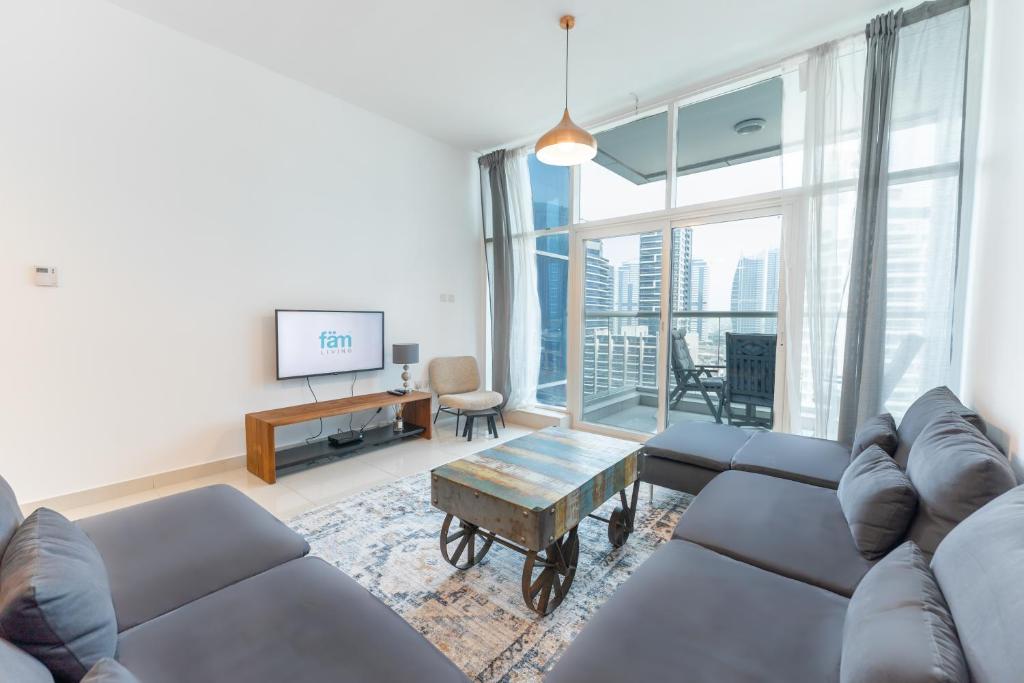 a living room with a couch and a tv at FAM Living - Continental Tower - 2B with Spectacular Marina Views in Dubai