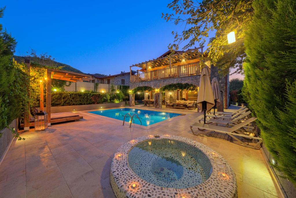 un cortile con piscina e una casa di VILLAS KAYAKOY 2 OLUDENIZ/FETHIYE a Fethiye