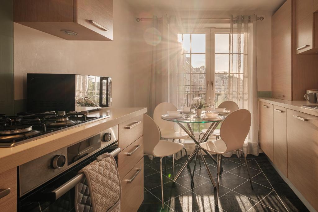 een keuken met een tafel met stoelen en een fornuis bij Mackie Residence - 3 Bed Apartment with parking in Westhill 