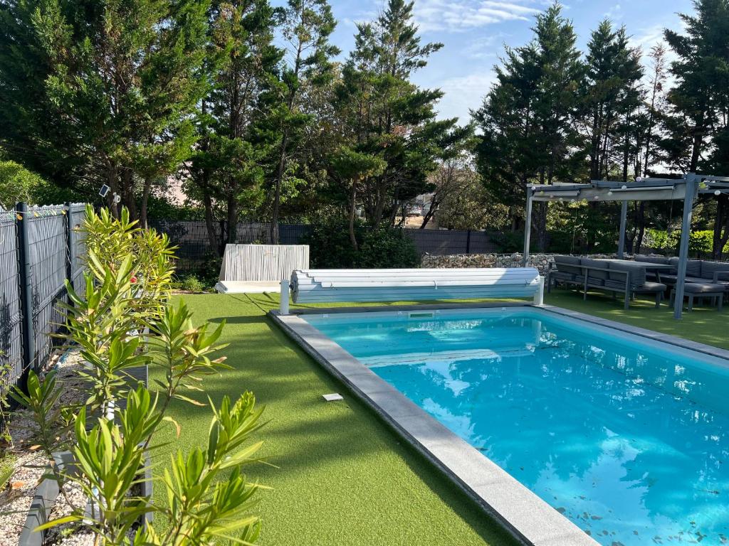 - une piscine dans une cour avec de l'herbe verte dans l'établissement Villa piscine & terrain tennis, à Méjannes-le-Clap