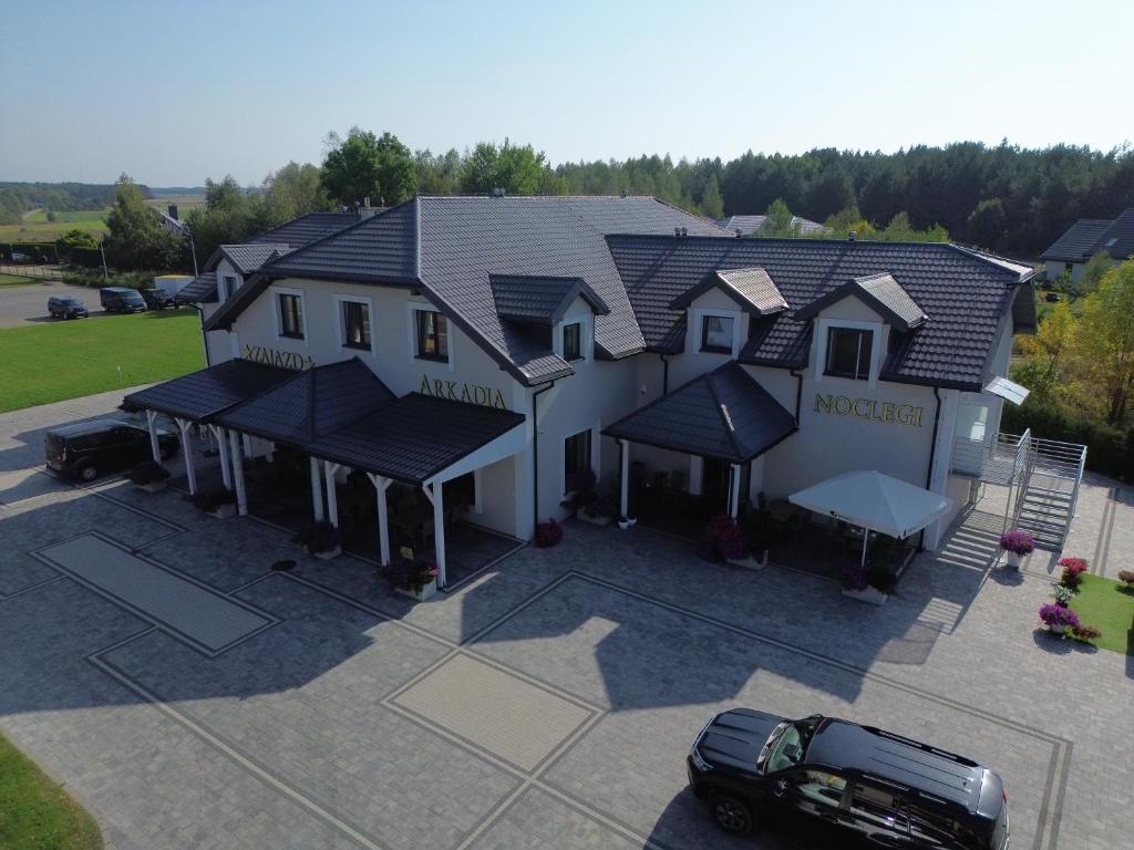 a house with a car parked in front of it at Zajazd Arkadia in Siemiatycze