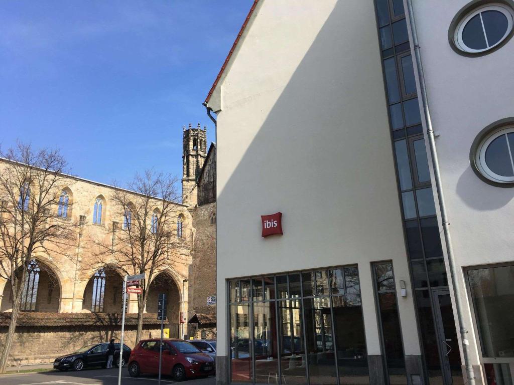 ein Gebäude auf einer Straße mit davor geparkt in der Unterkunft ibis Hotel Erfurt Altstadt in Erfurt