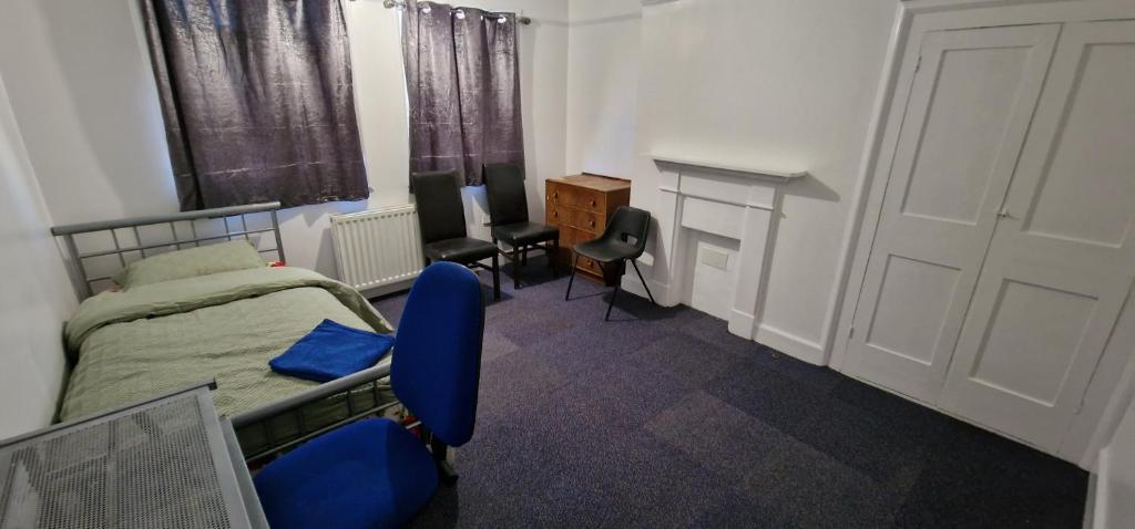 1 dormitorio con cama, escritorio y puerta en Grove Lane, en Ipswich