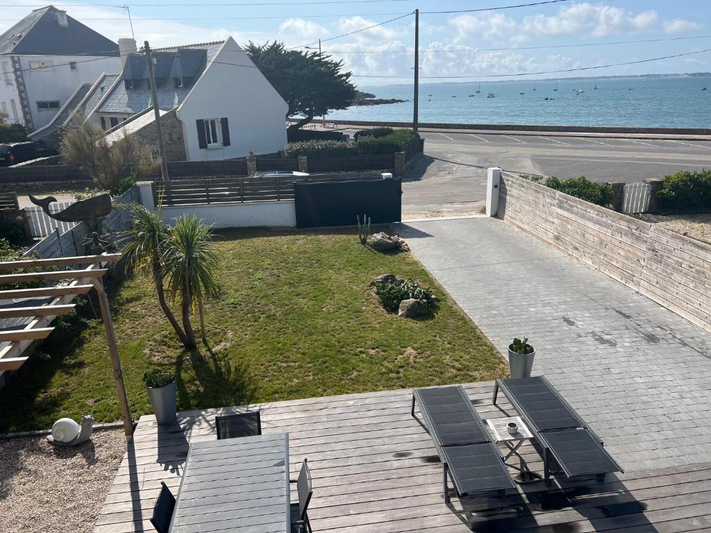 a deck with two benches and the ocean at Villa front de mer Carnac in Carnac