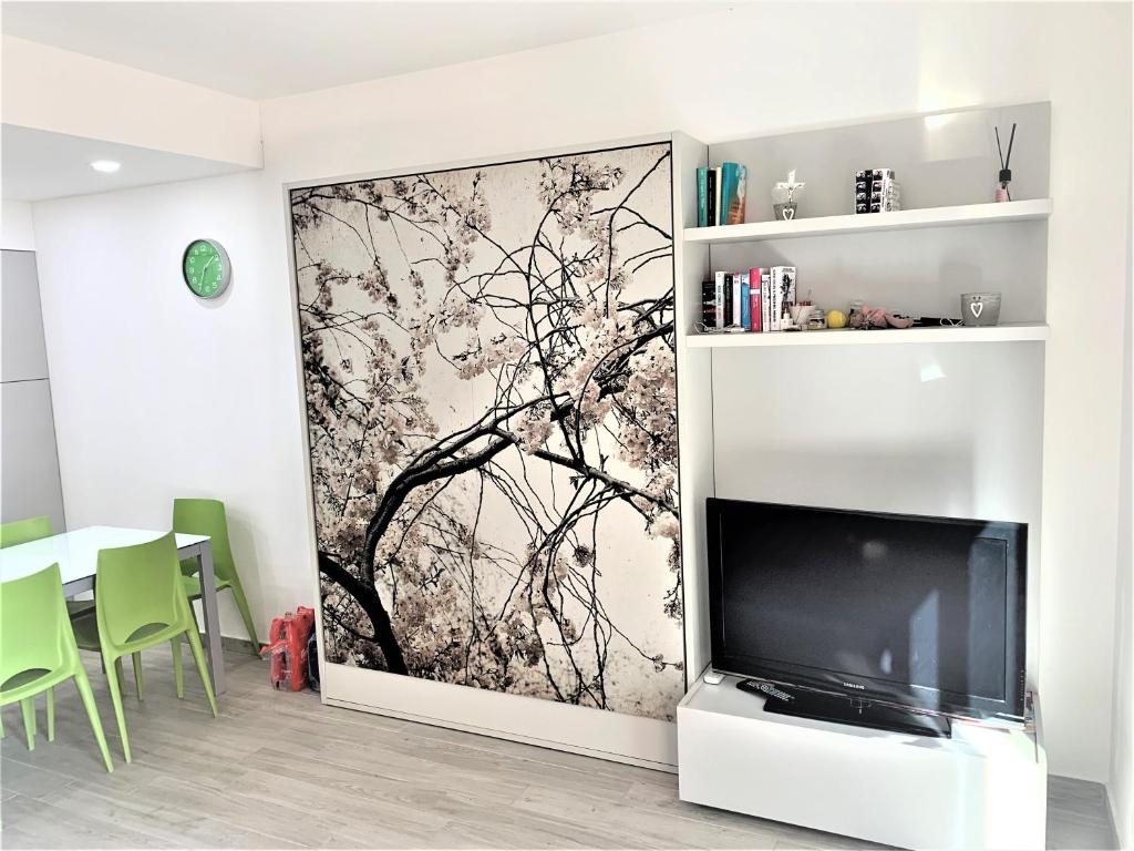 een woonkamer met een tv en een muurschildering bij Green House Varazze in Varazze
