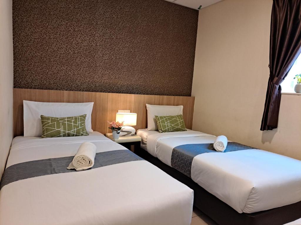 um quarto de hotel com duas camas e uma janela em SCC Gateway Chinatown Hotel em Kuala Lumpur