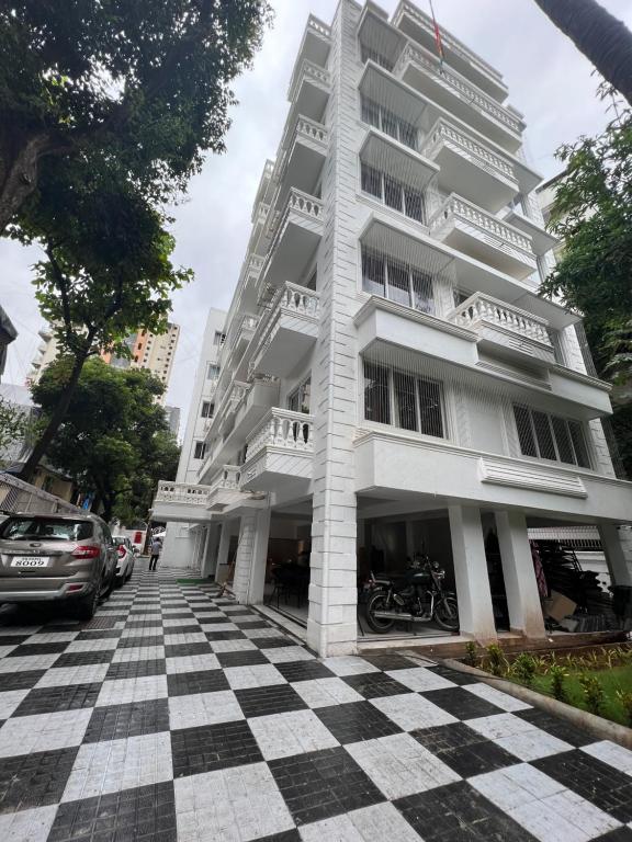 un edificio blanco alto con suelo a cuadros en White House by Maxxvalue Service Apartments Bandra en Bombay