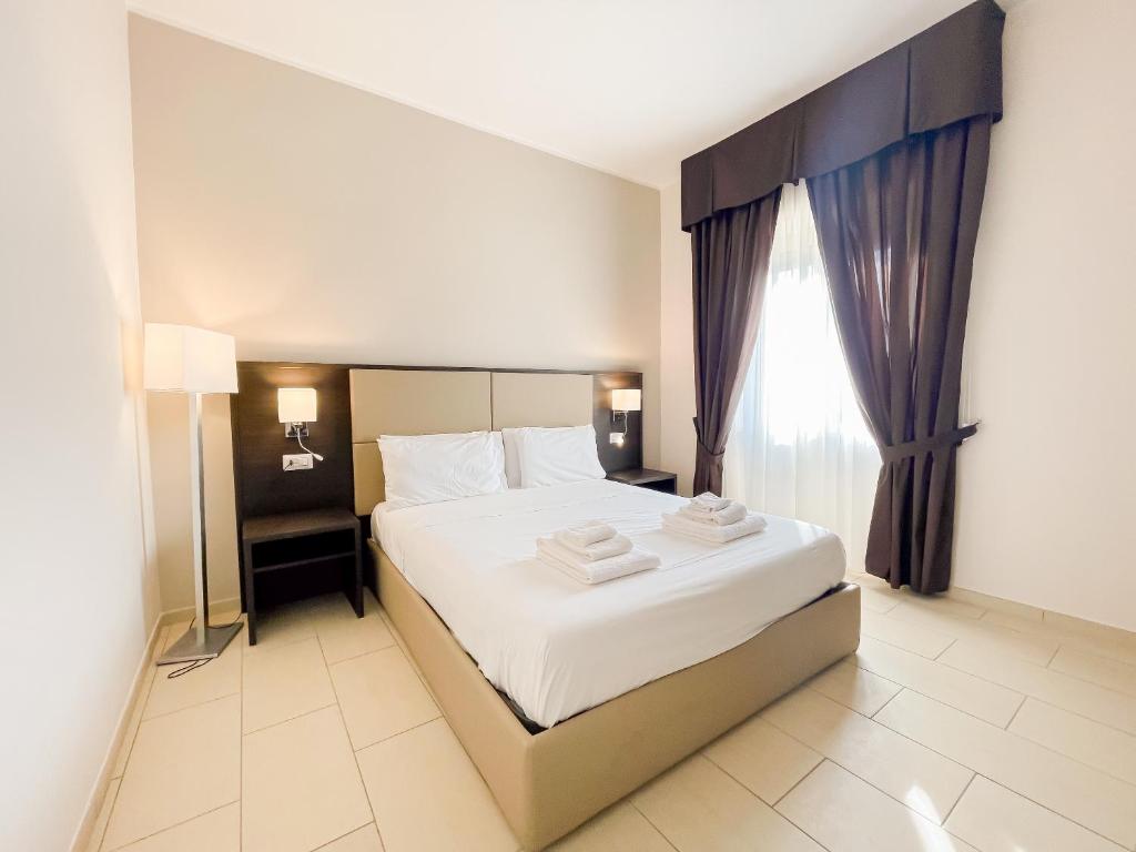 - une chambre avec un grand lit et des serviettes dans l'établissement Brain Apartment Pagani, à Pagani