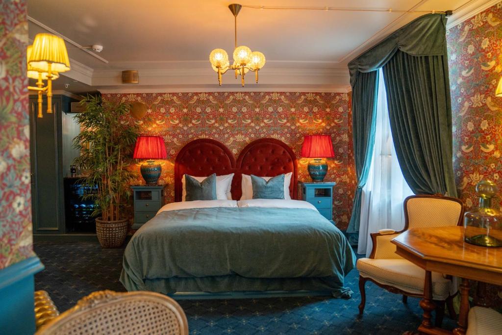 um quarto com uma cama, uma mesa e cadeiras em Charmante - Skostredet Hôtel em Bergen