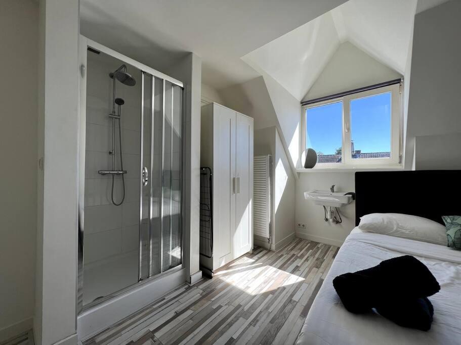 Room 505 - Eindhoven by T&S في أيندهوفن: غرفة نوم مع دش وسرير ومغسلة
