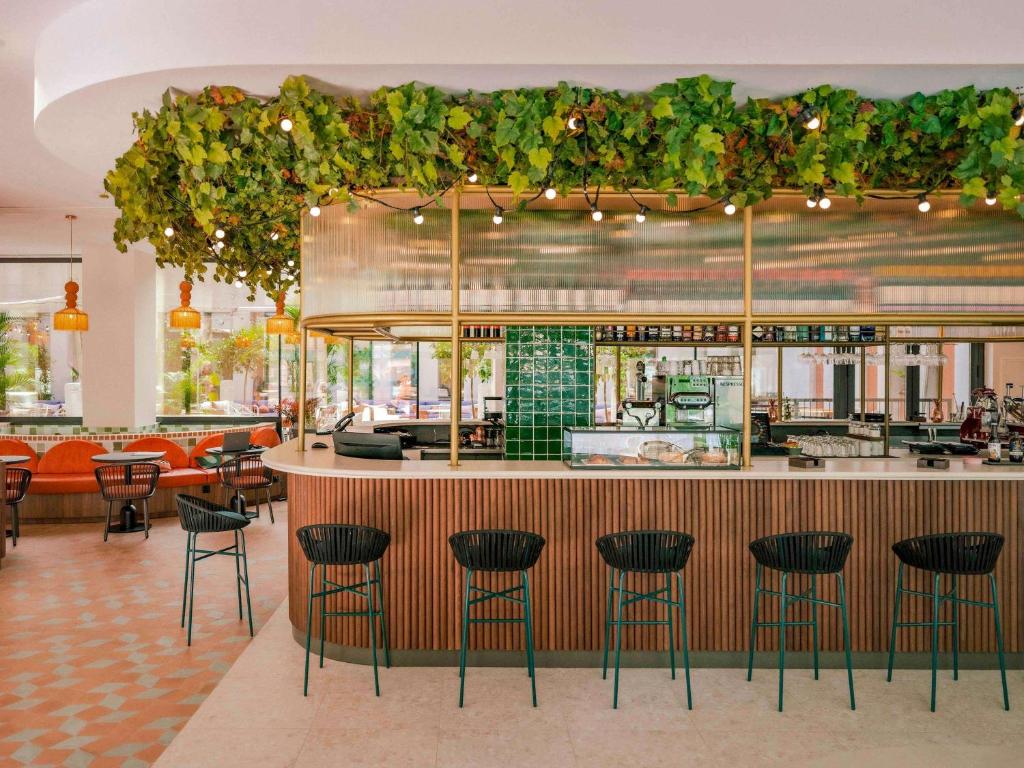 a restaurant with a bar with stools at Ibis Styles Sevilla City Santa Justa in Seville