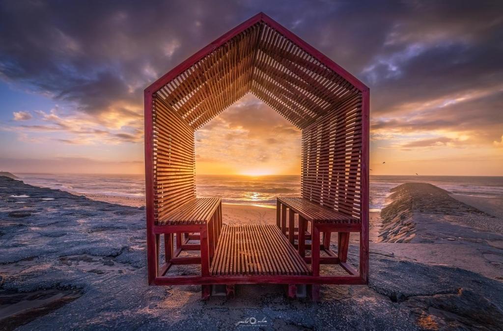 un proyector de madera con dos bancos sentados en una playa en Aromas Flavors Tours Esmoriz Beach, en Esmoriz