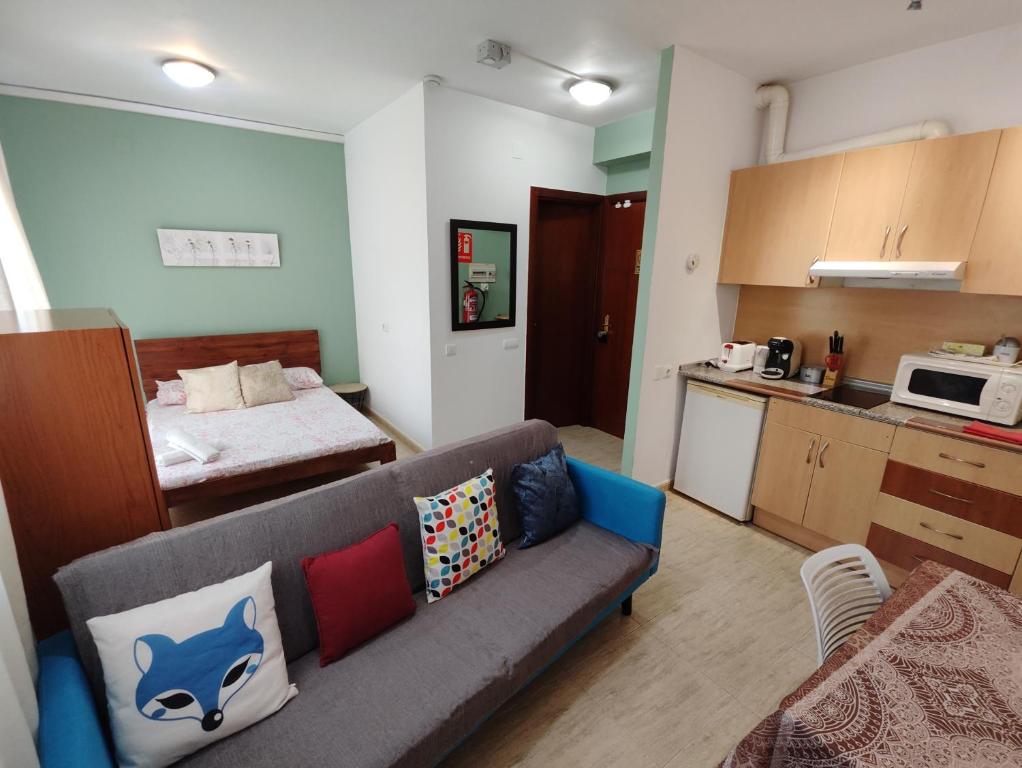 een woonkamer met een bank en een keuken bij Estudio en el centro in Reus