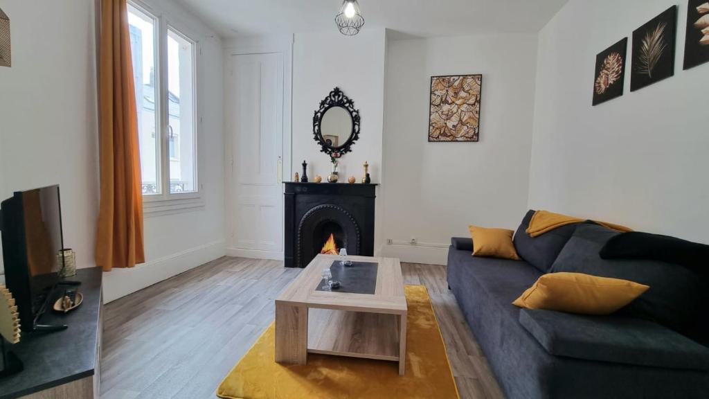 un salon avec un canapé et une cheminée dans l'établissement Chez K&D Studio Jaune Le Havre, au Havre