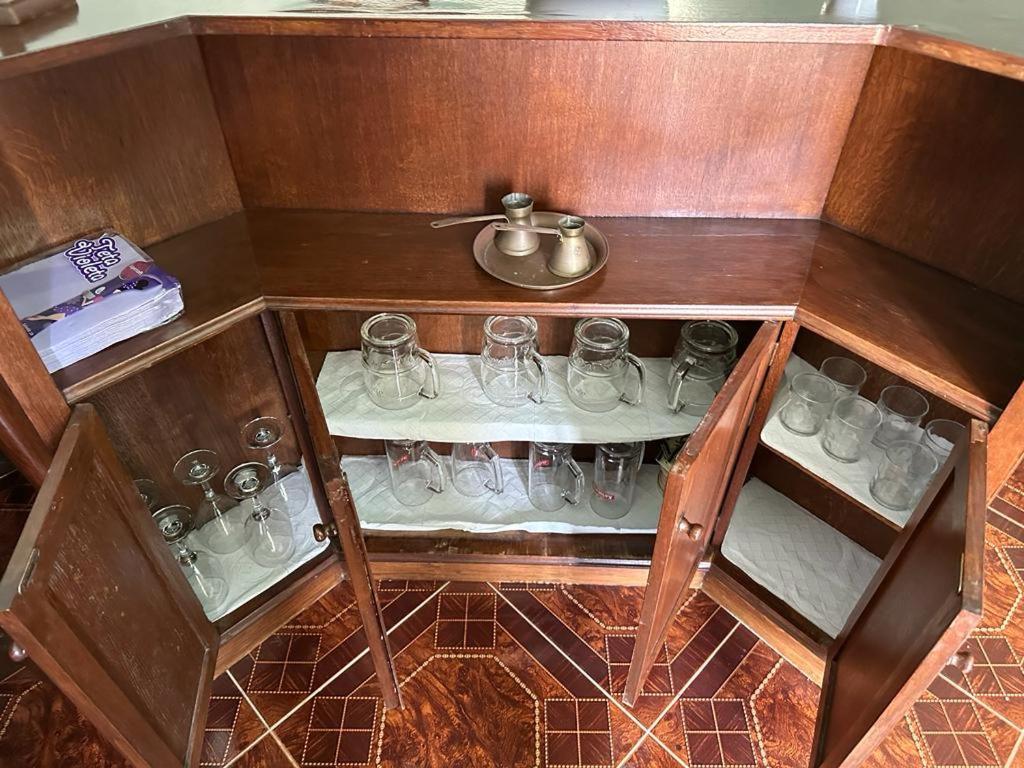 a wooden cabinet with glasses and a tea pot at Villa Kolorina in Dubrovnik