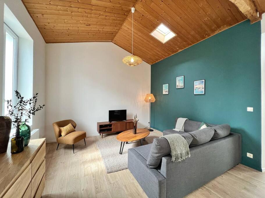 a living room with a couch and a table at L'évasion - Terrasse privée in La Rochelle