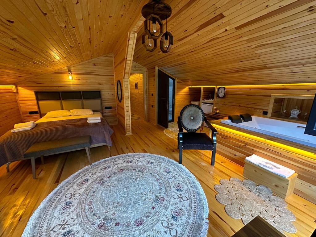 Zimmer mit einem Bett, einer Badewanne und einem Teppich in der Unterkunft Meydan Şelale Apart in Çamlıhemşin