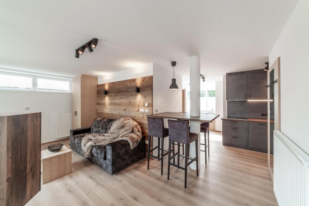 a kitchen and living room with a couch and a table at Dolomite Apartments 6&7 - by Familiaris in San Candido