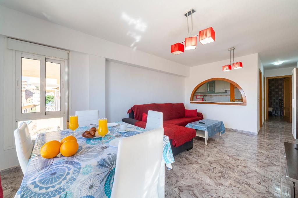 ein Wohnzimmer mit einem Tisch und einem roten Sofa in der Unterkunft Bahia Almeria in Aguadulce