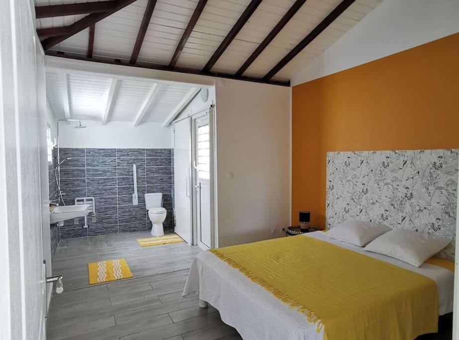 1 dormitorio con 1 cama grande y baño en 971B - La Villa ROUYO, villa créole accessible PMR, en Le Moule