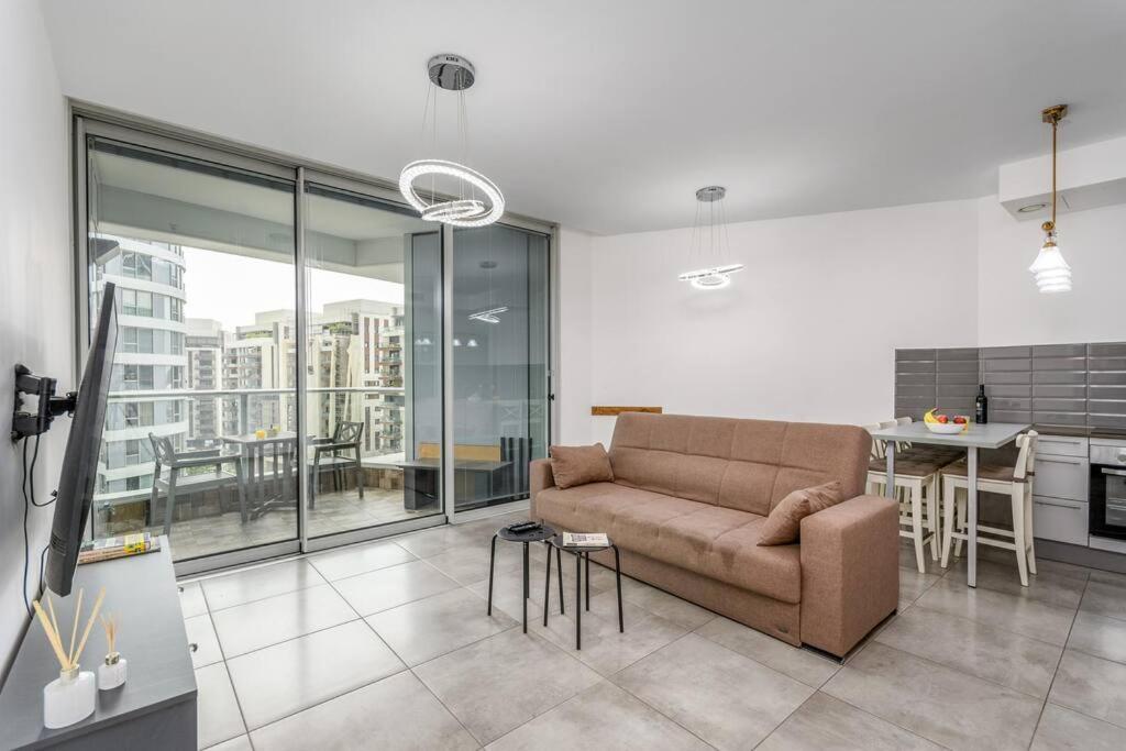 a living room with a couch and a kitchen at New Branch Gindi Tower 1BR with Parking in Tel Aviv