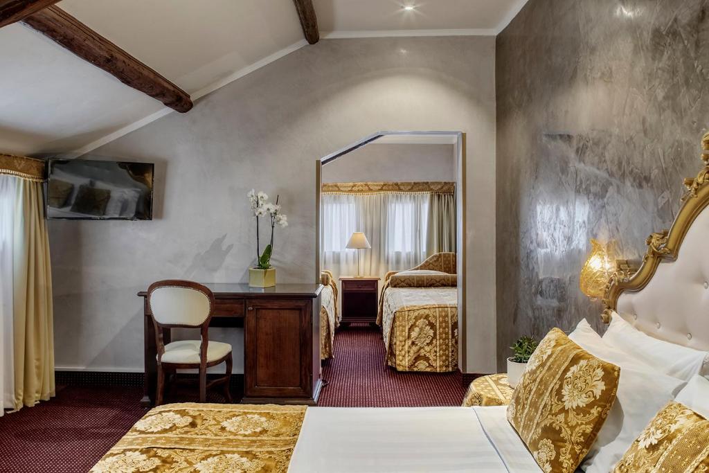 a hotel room with two beds and a mirror at Hotel Pausania in Venice