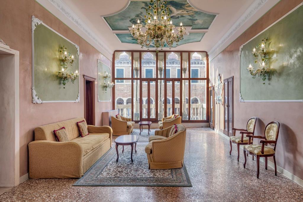 a living room with furniture and a chandelier at Hotel Pausania in Venice