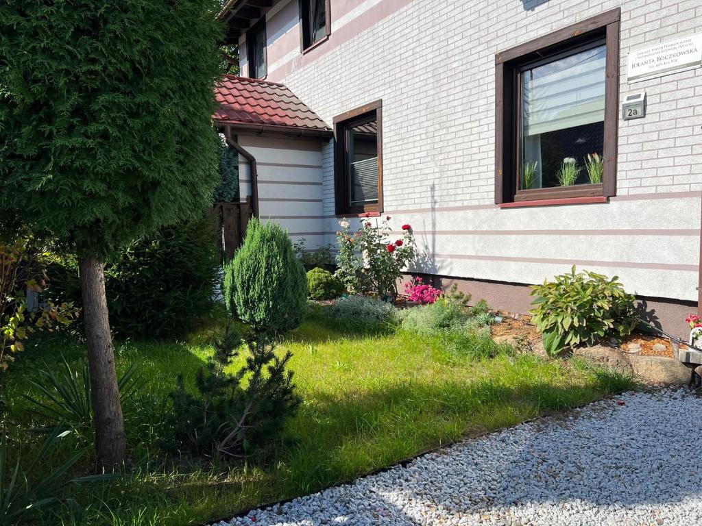 una casa con un patio con césped y flores en Apartament 4 plus 1 w Karkonoszach en Jelenia Góra