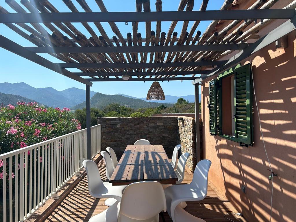 un patio avec une table et des chaises sur un balcon dans l'établissement Maison 6 personnes SaintFlorent, à Saint-Florent
