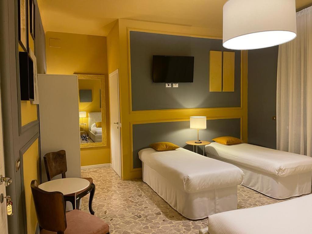 Central Suite Bed&Breakfast في بولونيا: غرفة فندقية بسريرين وتلفزيون