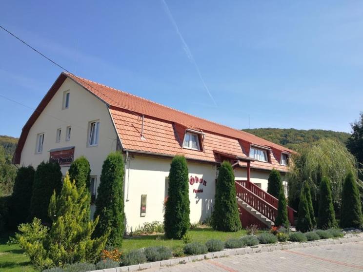 une grande maison blanche avec un toit rouge dans l'établissement Ódon Panzió, à Bükkszentkereszt