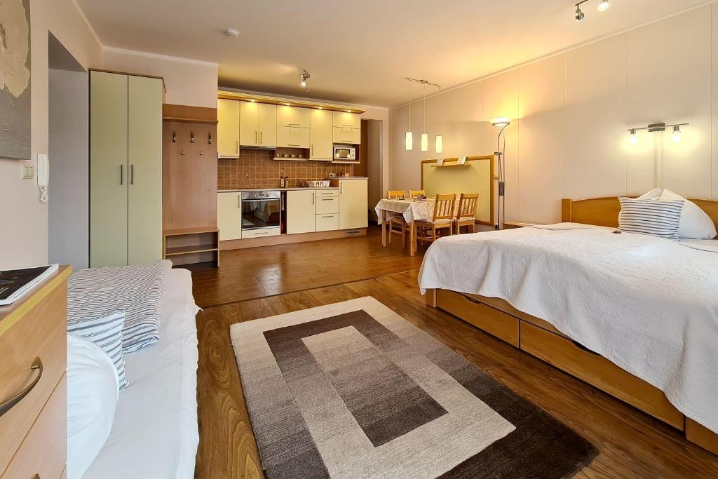シャールヴァールにあるAtmoszféra Apartmanのベッド2台、キッチンが備わる広い客室です。