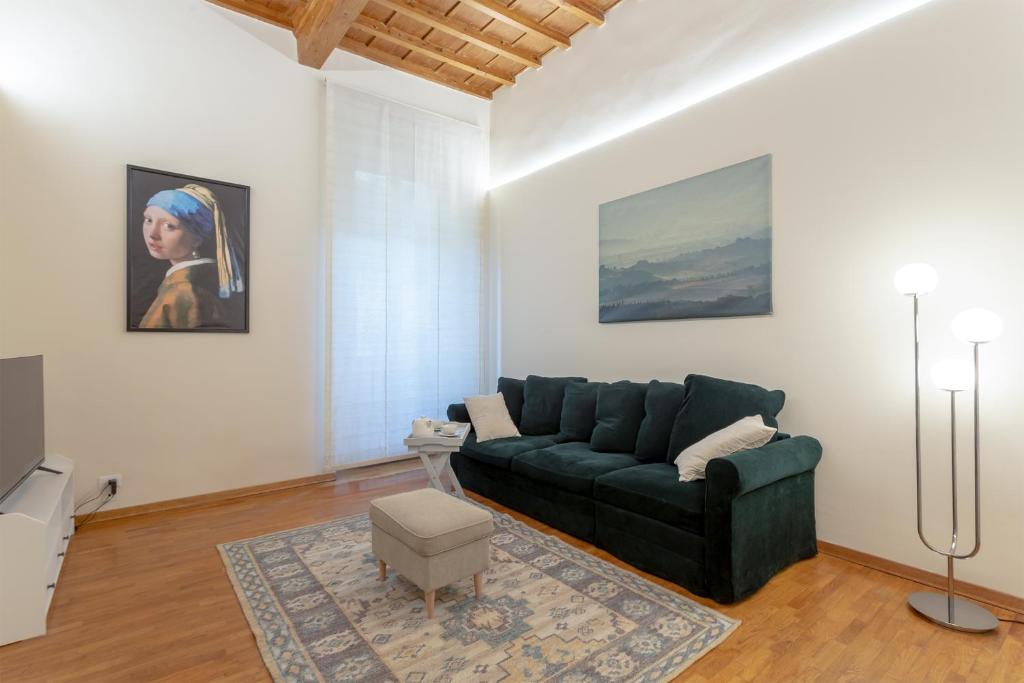 uma sala de estar com um sofá verde e um quadro em La Perla Del Borgo Apartment em Florença