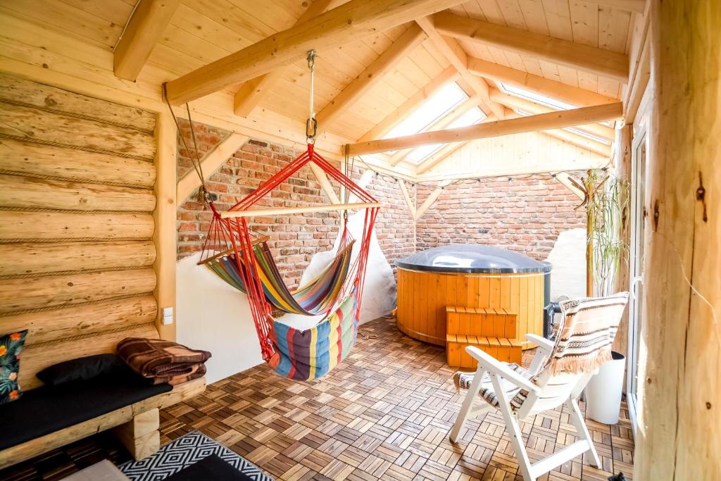 a room with a hammock and a barrel at Ciukrowa Chatka Sauna & Jacuzzi in Poronin
