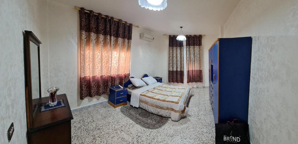 a bedroom with a bed and a window at Feel home always in Amman