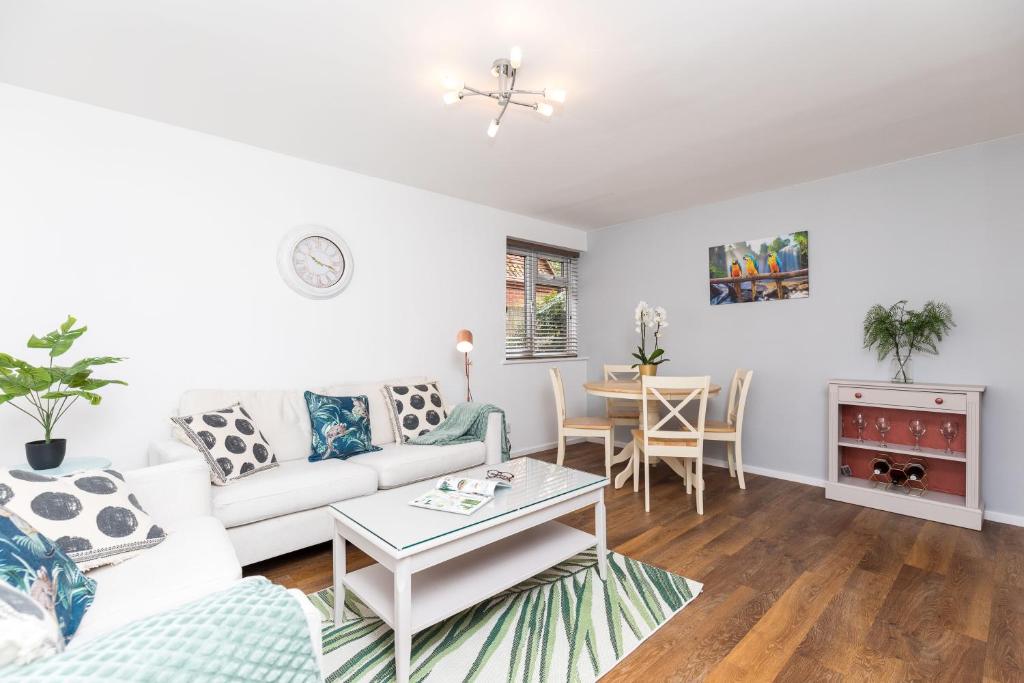 ein Wohnzimmer mit einem weißen Sofa und einem Tisch in der Unterkunft Rivermead in Horsham