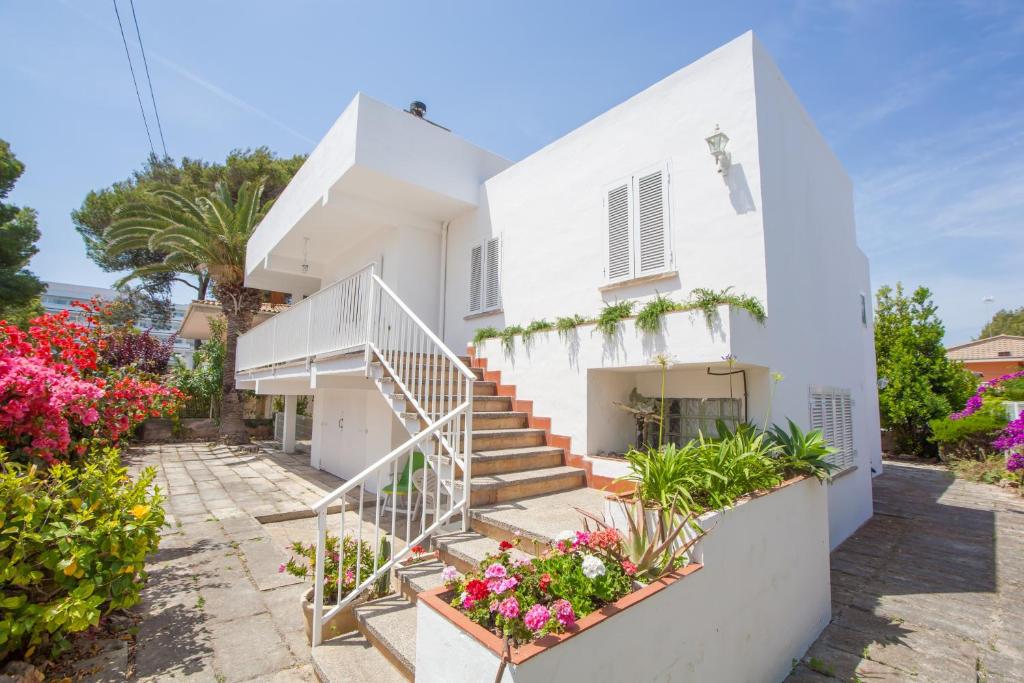 una casa blanca con escaleras y flores en Can Miquelet en Port d'Alcudia