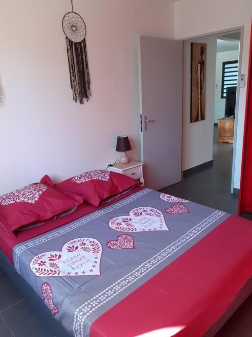 een slaapkamer met een bed met harten erop bij chez laly et mimy in La Possession