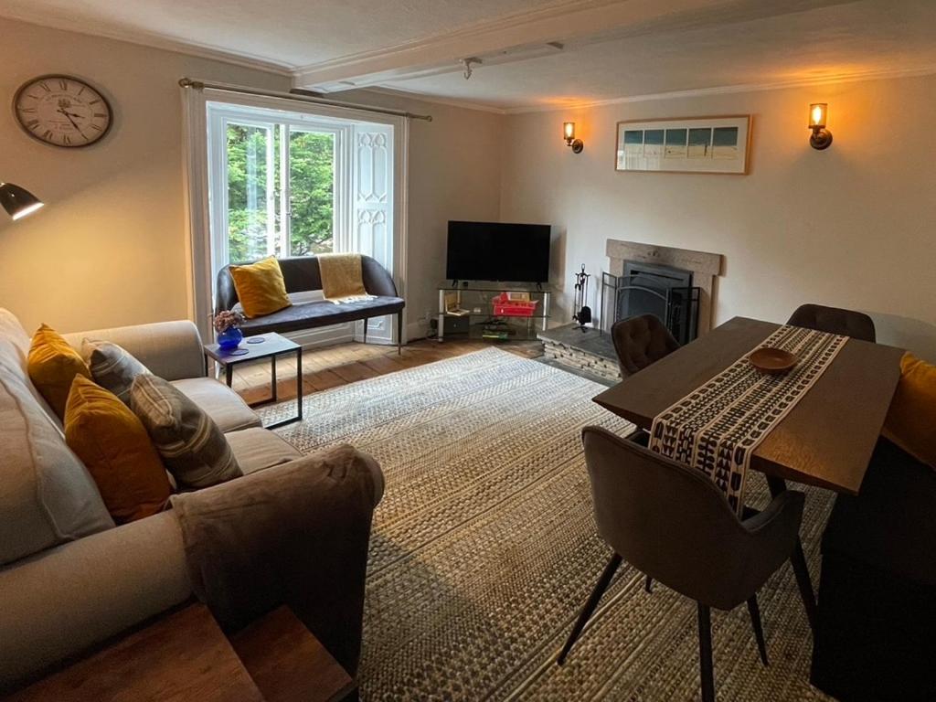 ein Wohnzimmer mit Sofa und Tisch in der Unterkunft Cosy Cottage for 6 & Pets Friendly in Hope Valley Pass the Keys in Stony Middleton