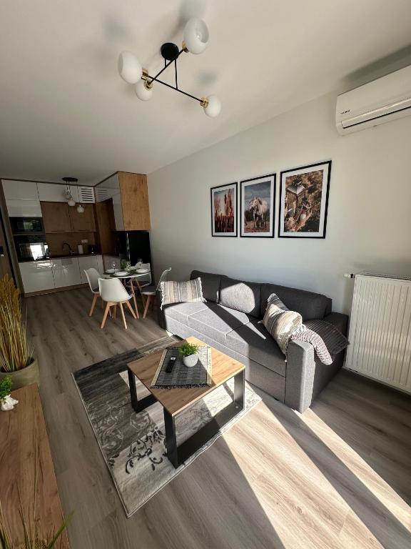 un soggiorno con un divano e un tavolo di SkyTravel 27 Apartament Pileckiego Nowy Dwór Mazowiecki Airport Modlin 24H a Nowy Dwór Mazowiecki