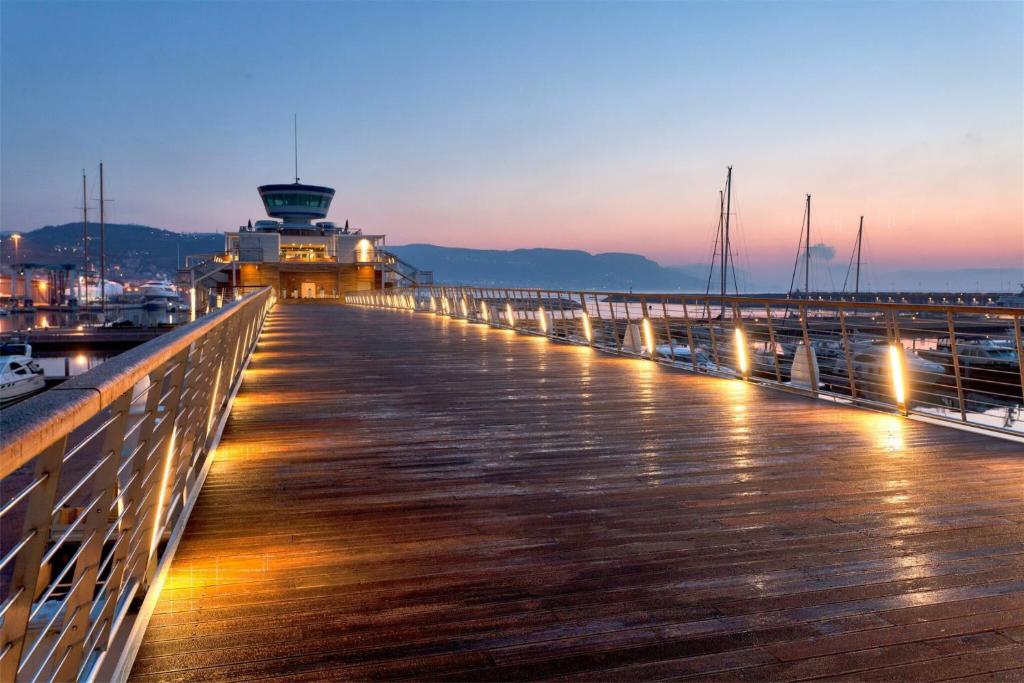 a pier with a lighthouse in the background at night at Romantic Chic Loä in Loano