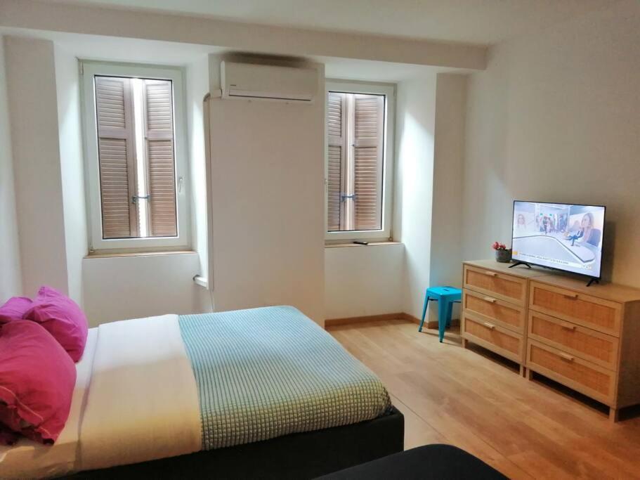 a bedroom with a bed and a dresser with a television at lucia haus trieste in Trieste