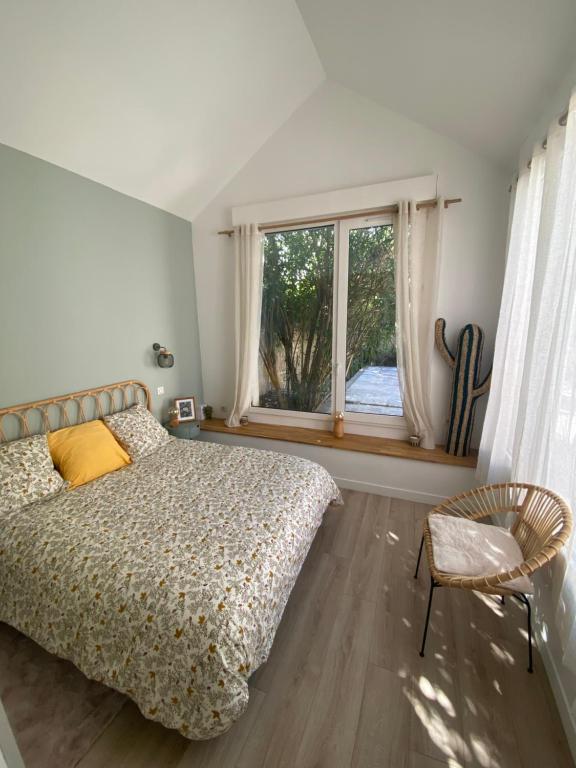 ein Schlafzimmer mit einem Bett, einem Fenster und einem Stuhl in der Unterkunft Saint Charles in Orléans