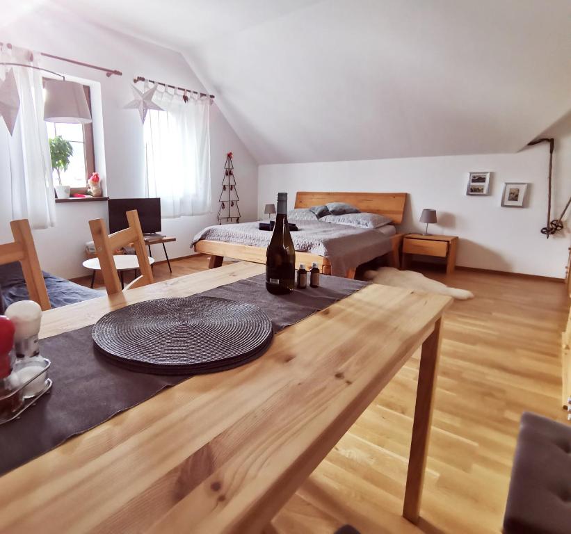 uma sala de estar com uma mesa e uma cama em Moji Sousedi - Apartmán Červená em Destné v Orlických horách