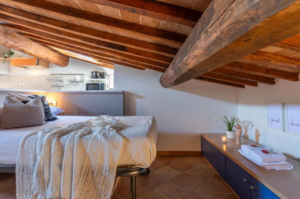 a bedroom with a bed and a wooden ceiling at Colours Studio 10 m away Piazza del Campo in Siena