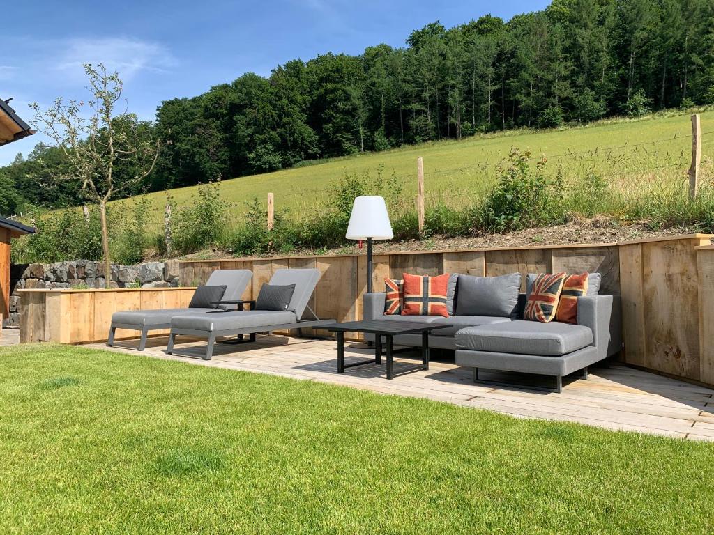 a patio with two couches and a table in a yard at Romantikhütte Grafschaft in Schmallenberg